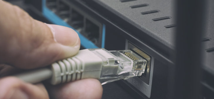Person plugging in cable to wireless router Firewall